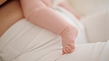 Anne ve kızı yatakta uzanıp, yatak odasında sarılıyorlar.