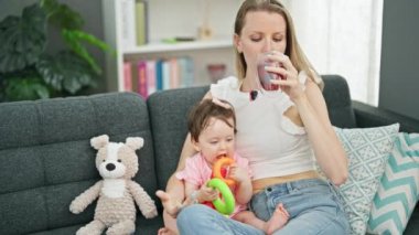 Anne ve kızı evde çember oynarken çay içiyorlar.