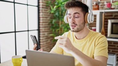 Yemek odasındaki masada oturan Latin asıllı genç bir adam.