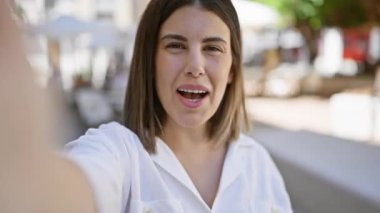 Genç, güzel, İspanyol bir kadın konuşuyor. Şehre el sallıyor.