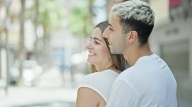 Güzel bir çift gülümsüyor. Sokakta birbirlerine sarılıyorlar.