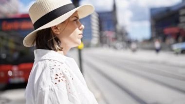 Stockholm sokaklarında ciddi bir ifadeyle yürüyen güzel, genç bir İspanyol kadın.