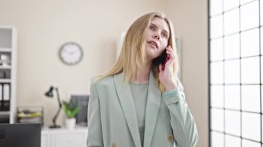 Young blonde woman business worker talking on smartphone working at office