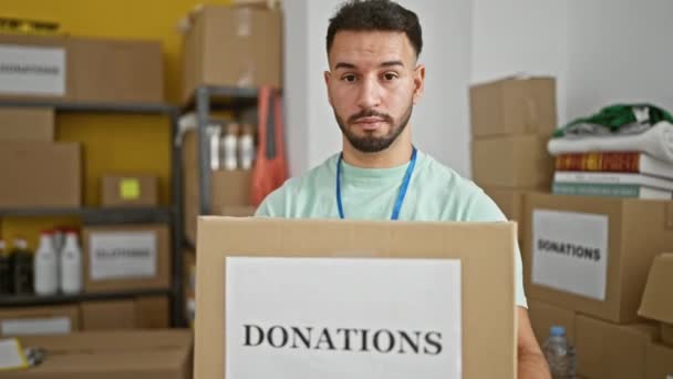 Joven Árabe Voluntario Sonriendo Confiado Sosteniendo Donaciones Paquete Centro Caridad — Vídeos de Stock