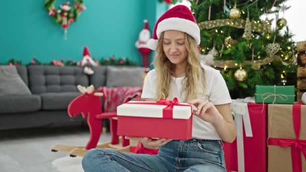 若い金髪の女性は 自宅でクリスマスを祝う贈り物をパック — ストック動画