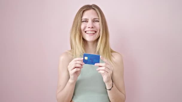 Mladá Blondýnka Žena Úsměvem Ukazuje Kreditní Kartu Přes Izolované Růžové — Stock video