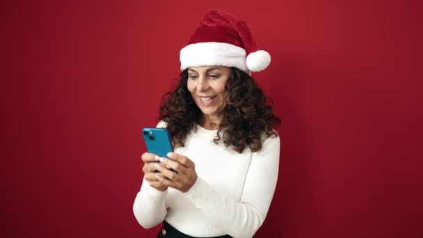 Medioevo Donna Ispanica Indossa Cappello Natale Utilizzando Smartphone Sfondo Rosso — Video Stock