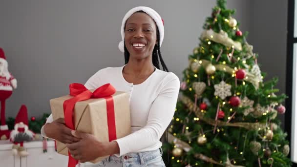 Afrikkalainen Amerikkalainen Nainen Jolla Lahja Seisoo Joulukuusi Kotona — kuvapankkivideo