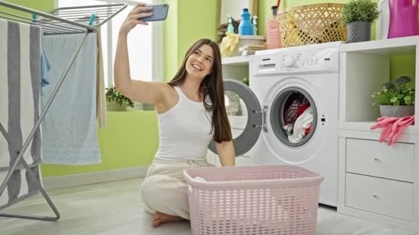 惊慌的女人在洗衣房用智能手机洗衣服 — 图库视频影像