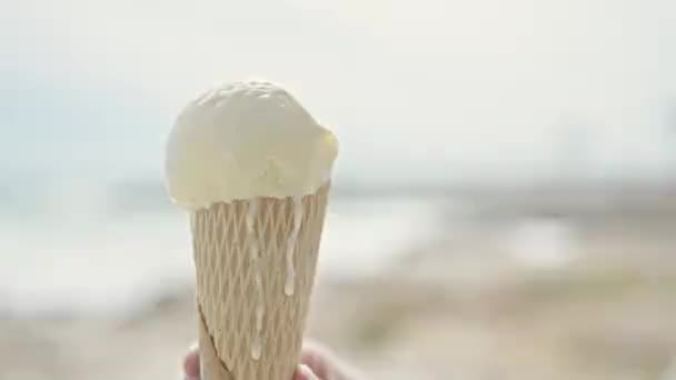 若い金髪の女性観光客が海辺でアイスクリームを食べる — ストック動画