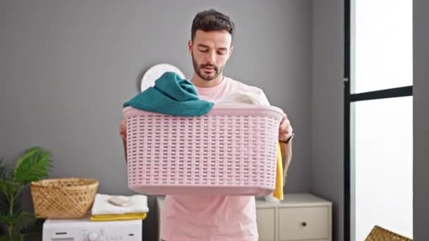 Young Hispanic Man Smiling Confident Smelling Clean Clothes Basket Laundry — Stock Video