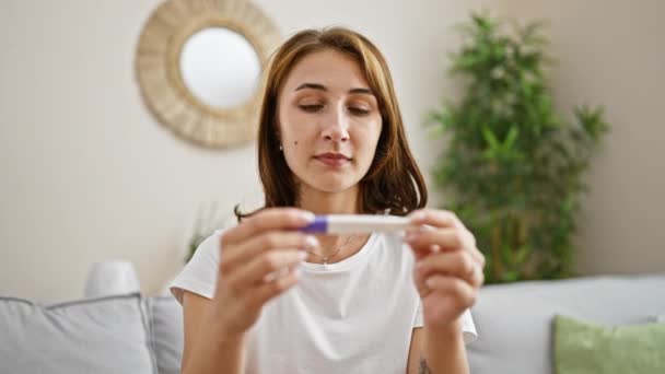 Νεαρή Γυναίκα Κάθεται Στον Καναπέ Κρατώντας Τεστ Εγκυμοσύνης Αναζητούν Αναστατωμένος — Αρχείο Βίντεο