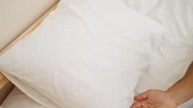 Genç İspanyol adam yatakta uzanıp yatak odasında uyuyor.