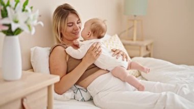 Anne ve kızı yatakta uzanıp, yatak odasında sarılıyorlar.