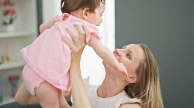 Anne ve kızı birbirlerine sarılıyorlar. Kanepede oturup öpüşüyorlar.