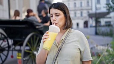 Genç ve güzel İspanyol kadın Viyana sokaklarında köpüklü çay içiyor.