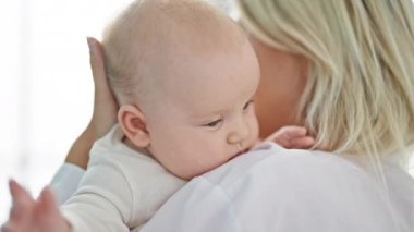 Anne ve kız çocuk doktoru klinikte birbirlerine sarılıyorlar.