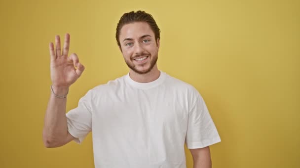 Jovem Hispânico Homem Sorrindo Confiante Fazendo Sinal Sobre Fundo Amarelo — Vídeo de Stock