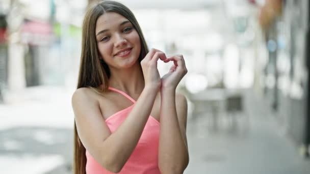 Молода Красива Дівчина Посміхається Впевнено Робить Жест Серця Руками Вулиці — стокове відео