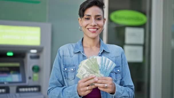 年轻美丽的惊慌失措的女人满脸笑容 自信地在银行出纳员面前拿着孩子们的比索钞票 — 图库视频影像