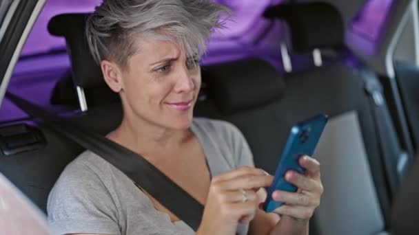 坐在车上的年轻女性乘客在街上用智能手机庆祝 — 图库视频影像