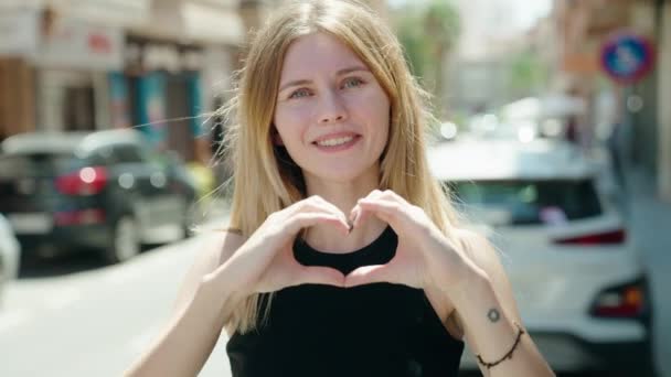 Young Blonde Woman Smiling Confident Doing Heart Gesture Hands Street — Stockvideo