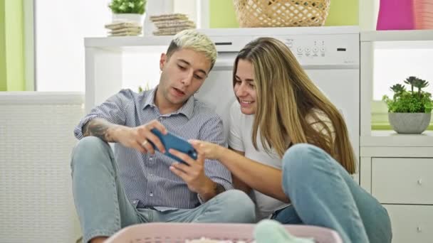 Beau Couple Regardant Vidéo Sur Smartphone Attendant Machine Laver Buanderie — Video