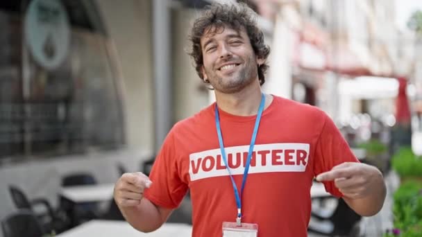 Jovem Ativista Hispânico Apontando Para Uniforme Voluntário Sorrindo Rua — Vídeo de Stock