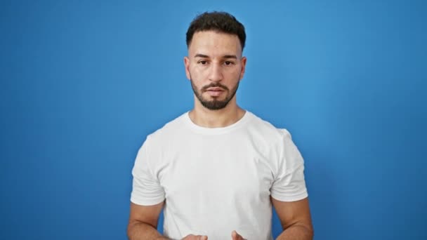 Junger Arabischer Mann Lächelt Selbstbewusst Und Spricht Über Isolierten Blauen — Stockvideo