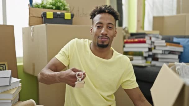 アフリカ系アメリカ人男性笑顔自信を持って保持新しい家の鍵で新しい家 — ストック動画
