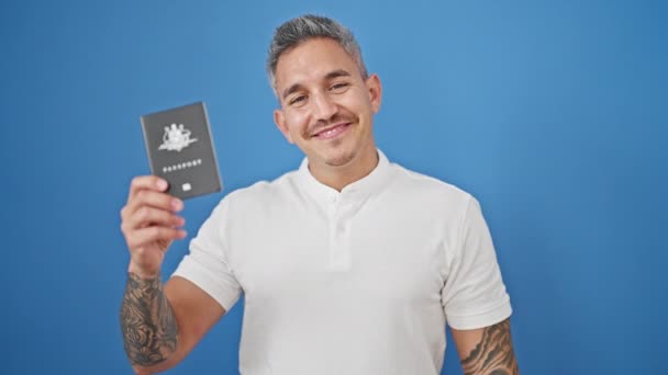 Mladý Hispánec Muž Usmívá Sebevědomě Drží Pas Přes Izolované Modré — Stock video
