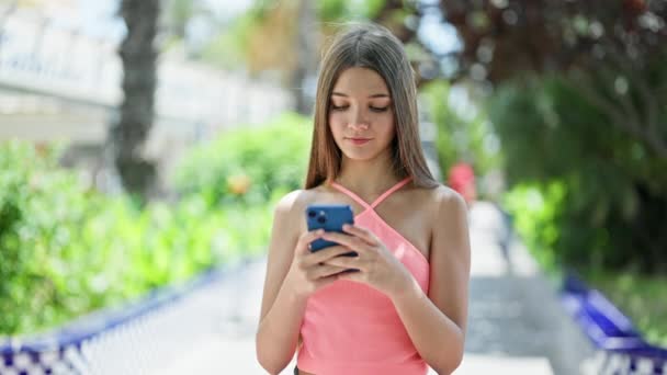Joven Hermosa Chica Usando Teléfono Inteligente Mirando Molesto Parque — Vídeo de stock