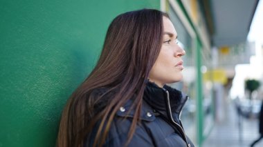 Young caucasian woman standing with serious expression at street