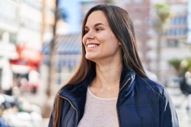 Young beautiful hispanic woman smiling confident looking to the side at street