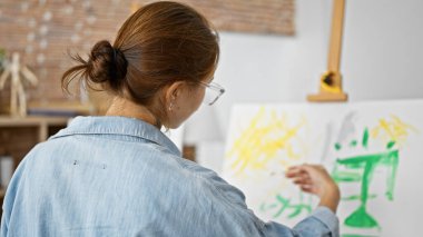 Sanat stüdyosunda çizim yapan genç bir kadın.