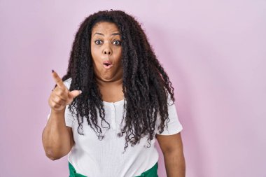 Artı, pembe arka planda dikilen boyunda bir İspanyol kadın parmağını yana çevirerek şaşırdı, ağzı açık hayret içinde kaldı.. 