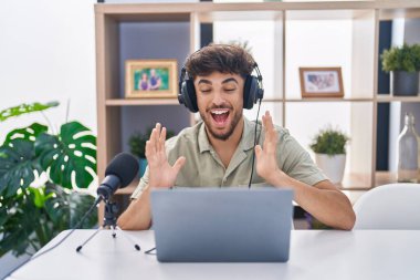 Radyoda çalışan sakallı bir Arap, başarının çılgınlığını kollarını kaldırarak ve gözleri kapalı heyecanla bağırarak kutluyor. Kazanan konsept 