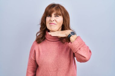 Orta yaşlı İspanyol bir kadın soyutlanmış arka planda duruyor. Bıçak niyetine boğazını kesiyor, saldırganlığı şiddetle tehdit ediyor. 