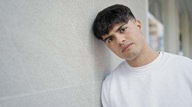 Sokakta ciddi bir ifadeyle duran İspanyol genç adam.