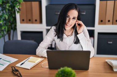 Young caucasian woman business worker using laptop and earphones working at office
