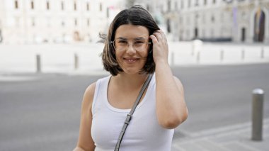 Viyana sokaklarında kendine güvenen güzel İspanyol kadın gülümsüyor.