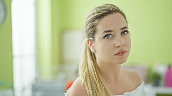 Çamaşır Odasında Ciddi Yüzüyle Müzik Dinleyen Genç Sarışın Kadın — Stok fotoğraf
