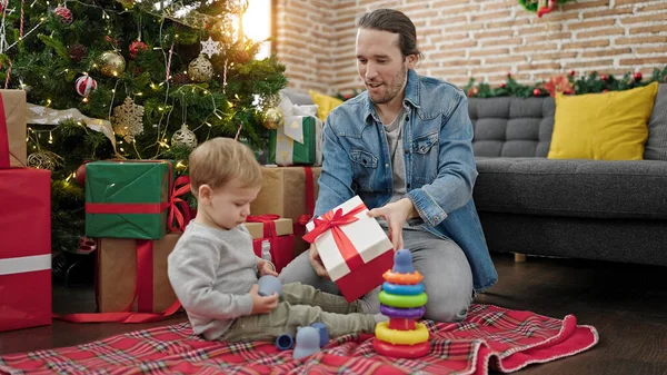 Father and son unpacking christmas gift playing with toys at home