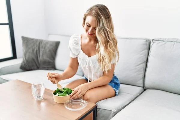 Young Woman Eating Salad Sitting Sofa Home — Stockfoto