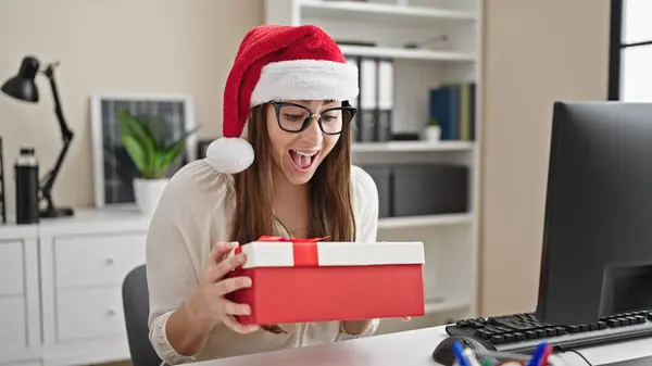 年轻美丽的他惊慌失措的女商人在办公室里拿着圣诞礼物 — 图库照片