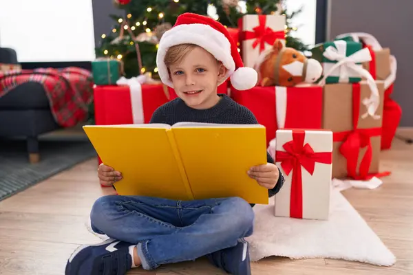 Sevimli Çocuk Evde Noel Ağacının Yanında Oturmuş Kitap Okuyor — Stok fotoğraf