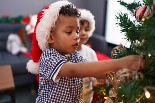 自宅でクリスマスツリーを飾る愛らしい少年 — ストック写真