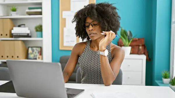 在办公室使用笔记本电脑思考的非洲裔美国女商人 — 图库照片
