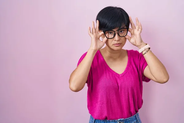 Jonge Aziatische Vrouw Met Kort Haar Staan Roze Achtergrond Proberen — Stockfoto
