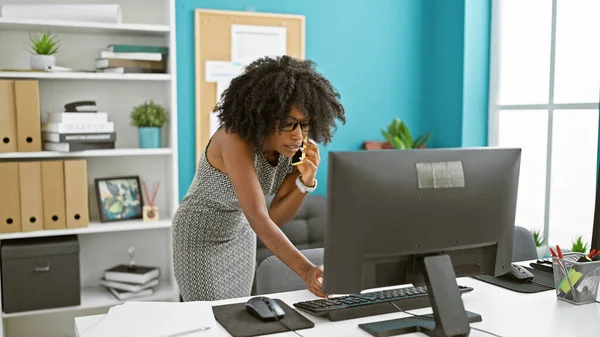 非洲裔美国女商人在办公室用电脑用智能手机交谈 — 图库照片